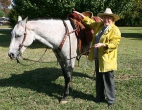 Barbara Taylor Bradford saddles a gray riding horse at the Lupton Ranch in Dallas, Texas